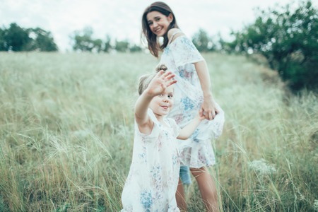 The young mother and daughter  on green grass backgroundの写真素材