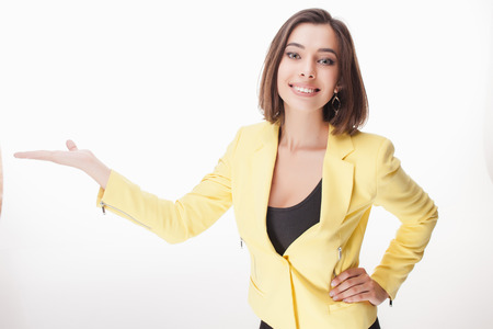 The young business woman showing something on the white backgroundの写真素材