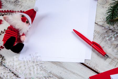 The blank sheet of paper on the wooden table with a pen and  Santa. Christmas mockup conceptの写真素材