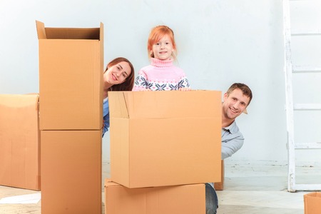 The happy family  at repair and relocation on a background of boxes