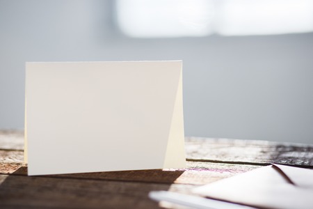 Blank invitation greetings card to replace your design on gray wooden table