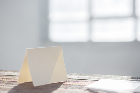 Blank invitation greetings card to replace your design on gray wooden tableの写真素材