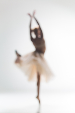 Blurred silhouette of ballerina dancing on white backgroundの写真素材