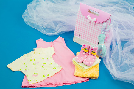 The baby clothes with a gift box on blue backgroundの写真素材