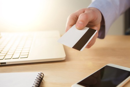 The man doing online shopping with credit card on laptop