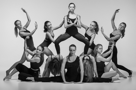 The group of modern ballet dancers posing on gray background. The black and white or colorless photoの写真素材