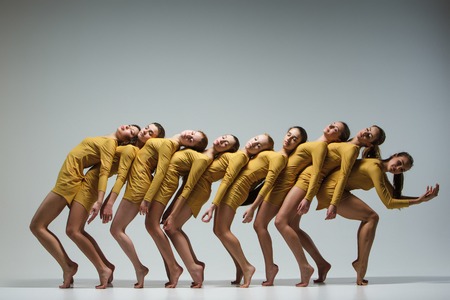 The group of modern ballet dancers dancing on gray backgroundの写真素材