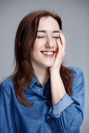 The young happy woman on gray background