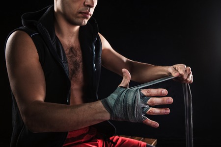 The hands with bandage of muscular man training kickboxing  on blackの写真素材