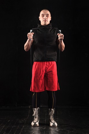 The legs of muscular man with skipping rope training kickboxing  on blackの写真素材