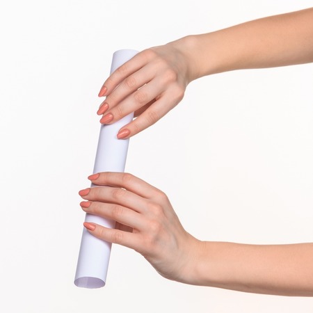 The white cylinder of the props in the female hands on white background with  right shadowの写真素材