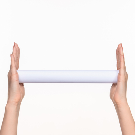 The white cylinder of the props in the female hands on white background with  right shadowの写真素材