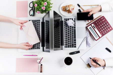 Concept of comfortable male and female workplaces. Gadgets on the white deskの写真素材