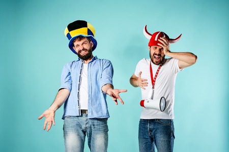 The two football fans with mouthpiece over blue background