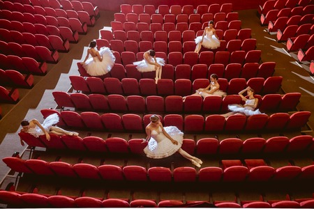 The ballerinas sitting in the empty auditorium theater