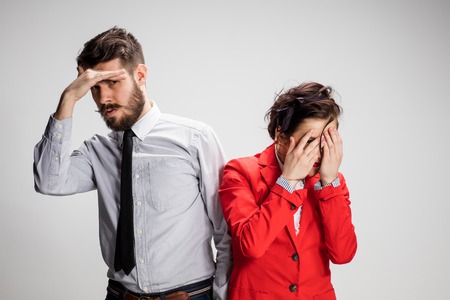 The business man and woman on a gray background closing eyesの写真素材