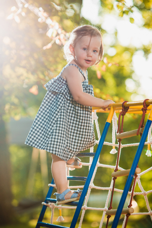 The little baby girl playing at outdoor playground against green grassの写真素材