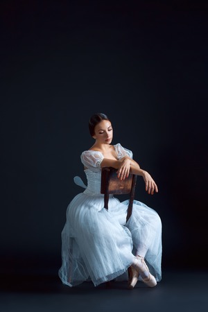 Portrait of the classical ballerina in white dress on the black backgroundの写真素材