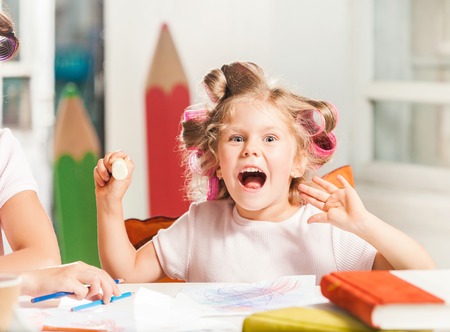 The young mother and her daughter drawing with pencils at homeの写真素材