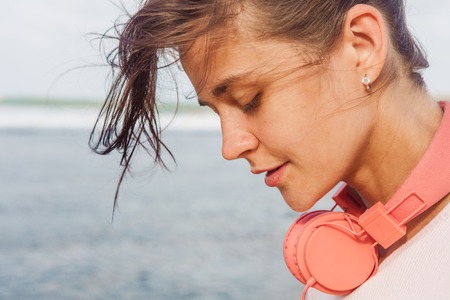 The woman with headphones walking on the beachの写真素材