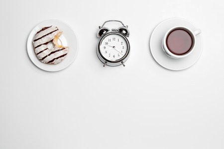 Clock, cup and cake on white backgroundの写真素材