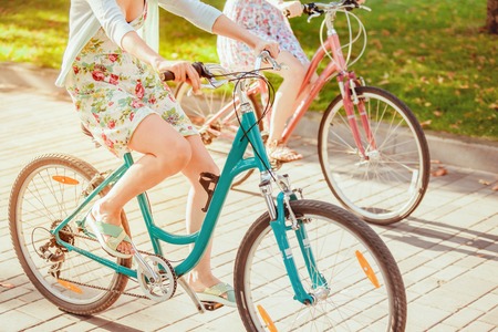 The two young girls with bicycles in park in summerの写真素材