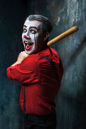 The scary clown and baseball-bat on dack. Halloween concept of horror and murdererの写真素材