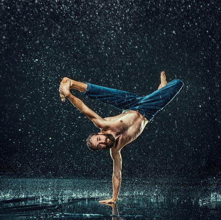 The male break dancer in water on dark background.の写真素材