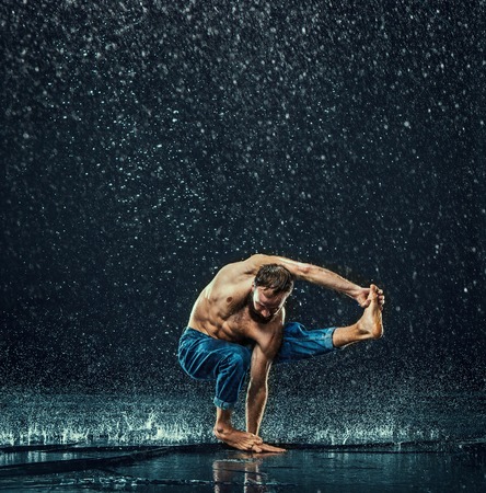 The male break dancer in water on dark background.の写真素材