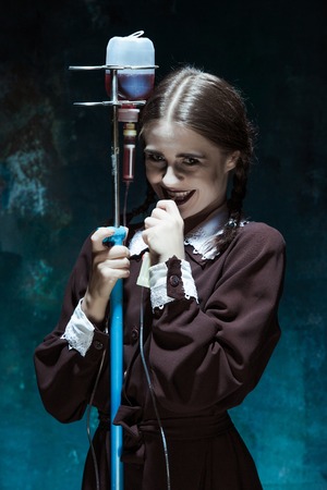 Portrait of a young girl with drop counter as a vampire woman against school board . The image in the style of Halloweenの写真素材