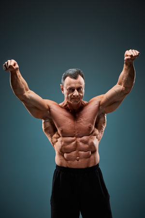 The torso of attractive male body builder on gray background.の写真素材