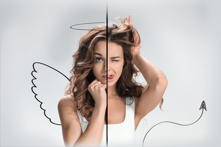 Photo of the girl with a different emotions on a face of the angel and the devil. Collageの写真素材