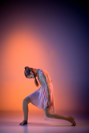 The female teen modern ballet dancer on orange studio backgroundの写真素材