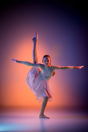 The female teen modern ballet dancer on orange studio backgroundの写真素材
