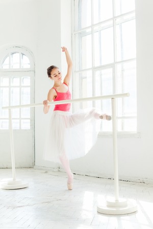 Ballerina posing in pointe shoes at the white wooden pavilionの写真素材