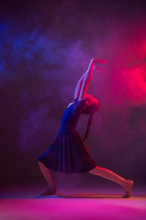 The female teen modern ballet dancer on blue and pink studio background