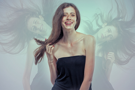 The young woman's portrait with happy emotions on gray background.の写真素材