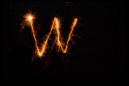 The English letter W made of sparklers on black backgroundの写真素材