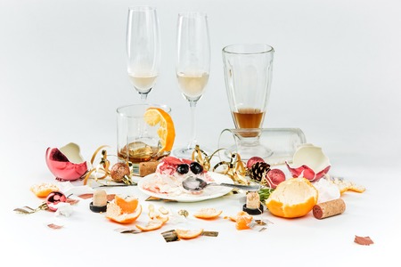 The morning after christmas day, table with alcohol and leftovers from a celebratory feast on grayの写真素材