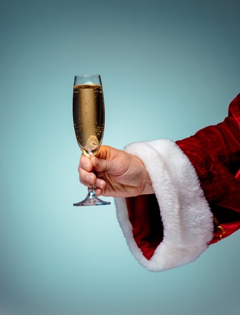 Santa Holding Champagne wineglass over blue backgroundの写真素材