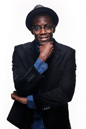 The portrait of handsome young black african smiling man in hat on dark background. Positive human...