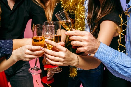 Many young women and men drinking at christmas party on white studio backgroundの写真素材