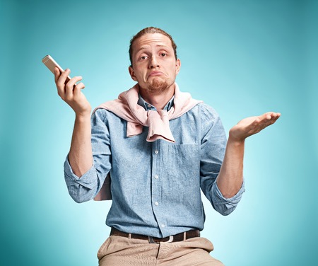 The young surprised caucasian man on blue backgroundの写真素材