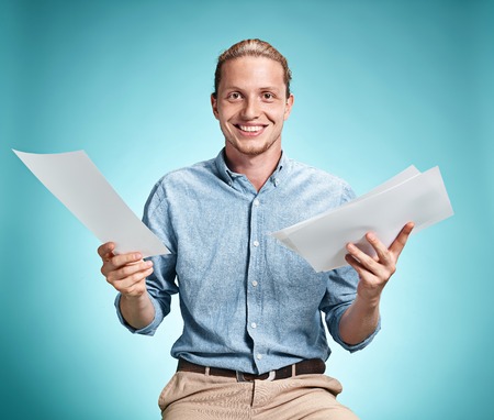 Smart smiling student with great idea holding sheets of paper