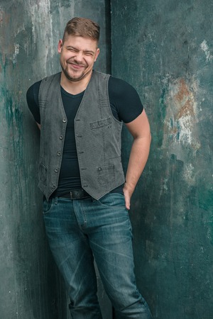 Portrait of smiling happy man standing in studioの写真素材