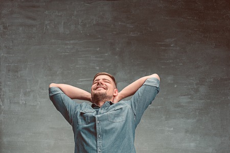 Portrait of smiling happy man standing in studioの写真素材