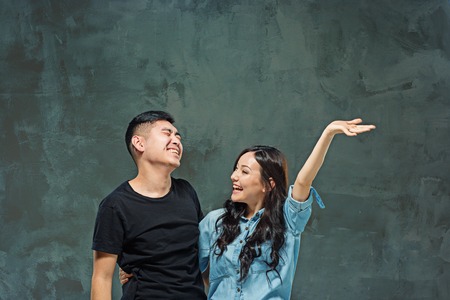 Portrait of smiling Korean couple on a grayの写真素材