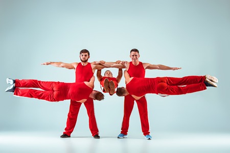 The group of gymnastic acrobatic caucasian men on balance pose