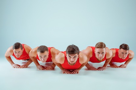 The group of gymnastic acrobatic caucasian men on balance poseの写真素材