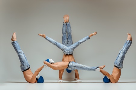 The group of gymnastic acrobatic caucasian men on balance poseの写真素材